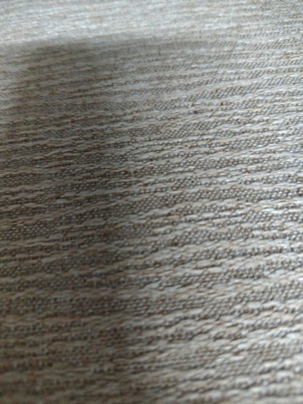 Close-up of fabric surface on used beige nightstand showing light soiling and texture
