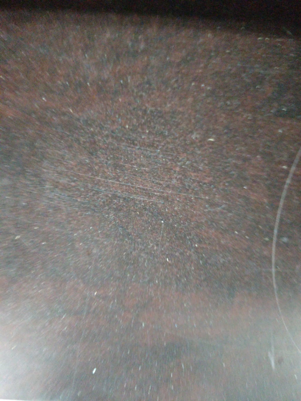Close-up of top surface of used dark brown nightstand showing scratches and surface wear