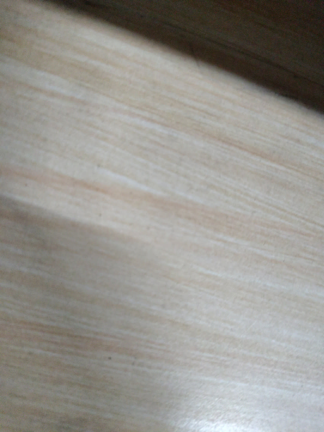 Close-up of beige wood-effect surface of used 3-drawer mobile pedestal filing cabinet at Bufaisal