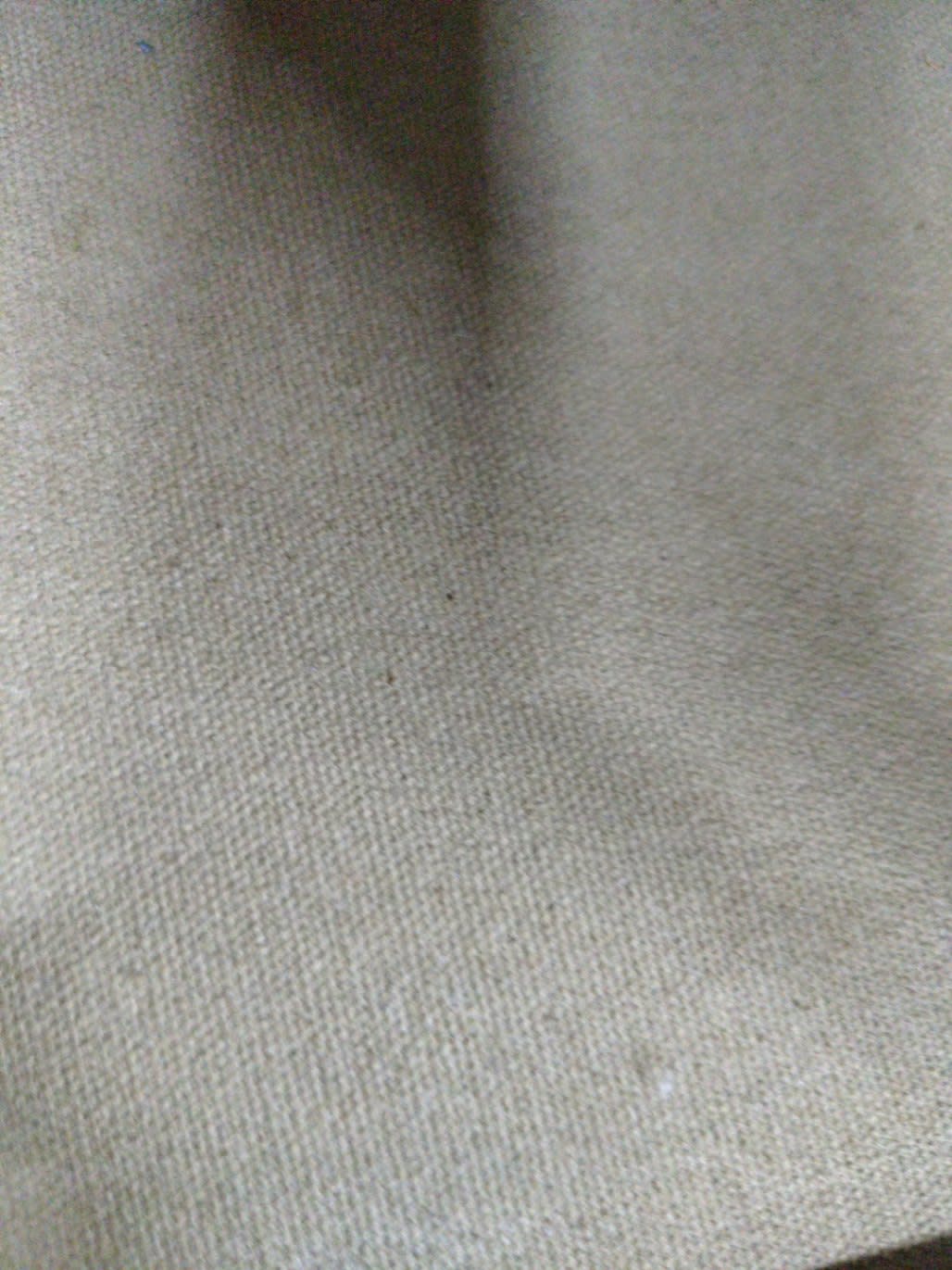 Close-up of fabric drawer lining on used trunk-style nightstand showing light dust spots