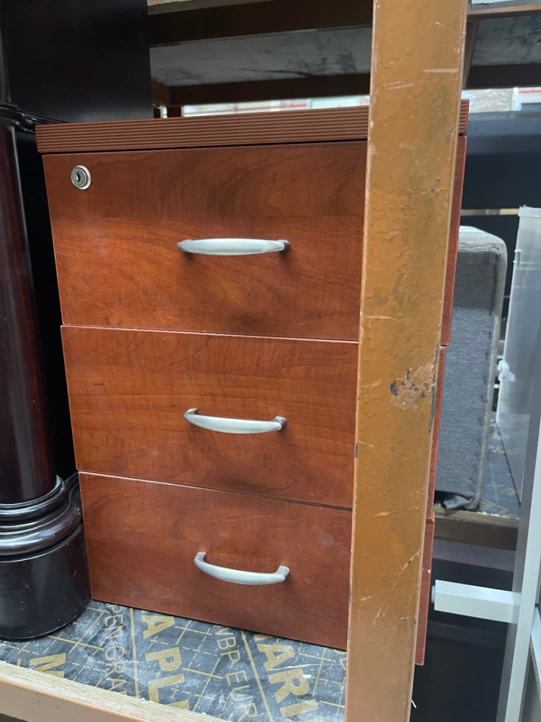 Side view of used cherry wood 3-drawer filing cabinet with lock showing minor surface scuffs
