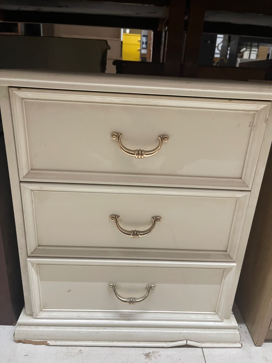 Additional front view of used cream 3-drawer nightstand showing base chip damage at Bufaisal Ajman
