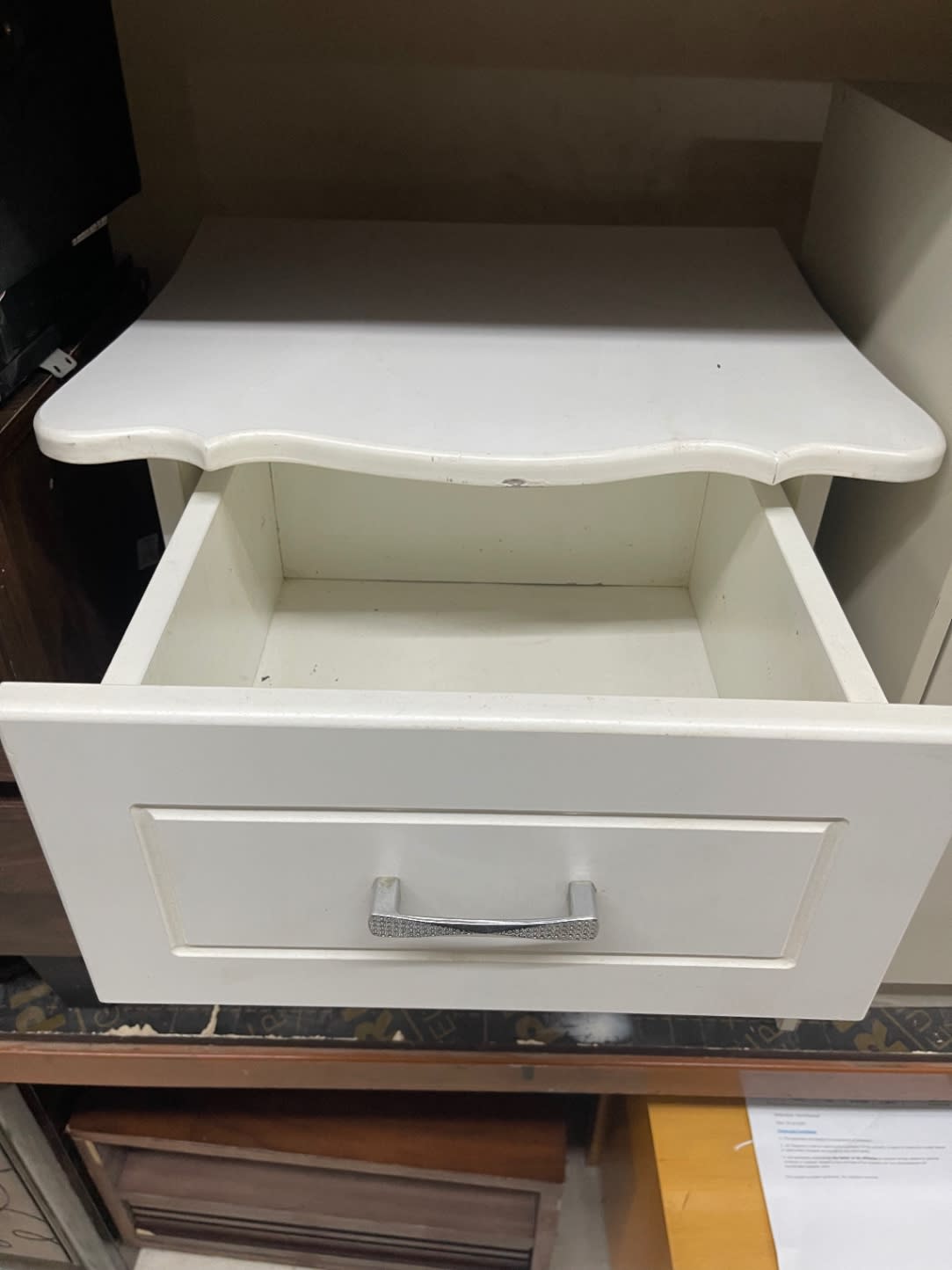 Upper drawer open on used white nightstand showing interior and scalloped top detail at Bufaisal Ajman