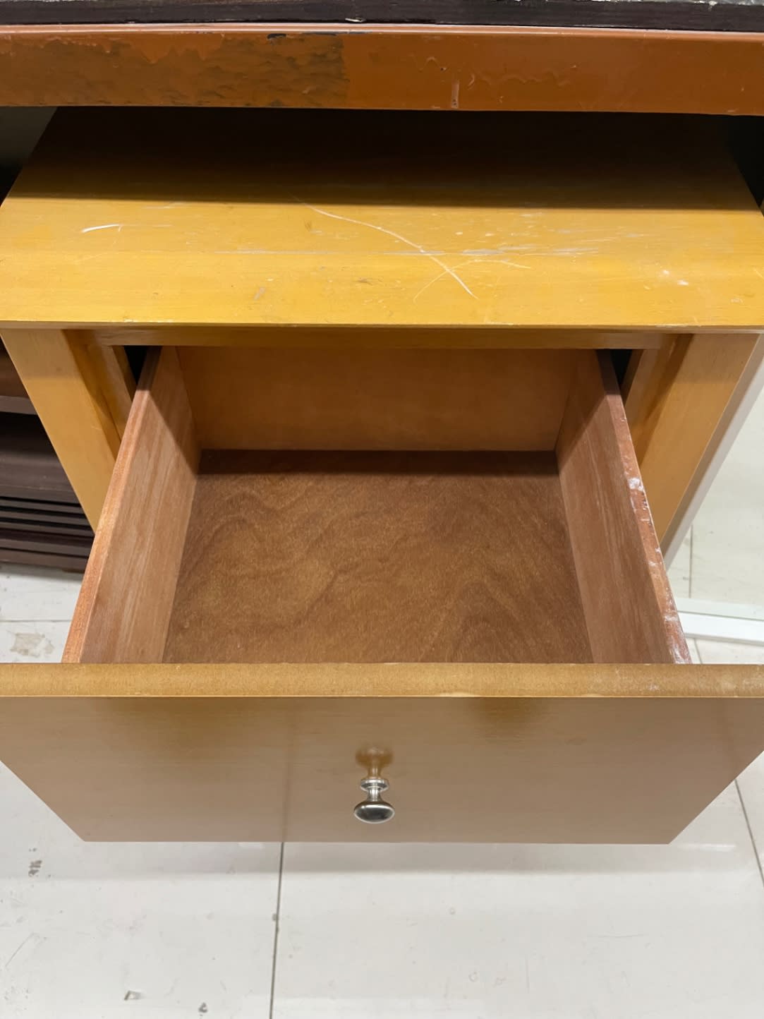 Top surface of used 2-drawer nightstand showing surface scratches with open drawer at Bufaisal Ajman