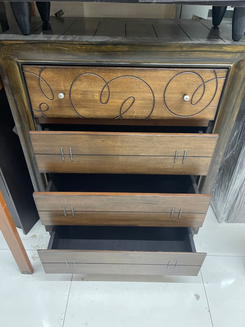 Multiple drawers open on used 5-drawer chest of drawers brown wood at Bufaisal Ajman