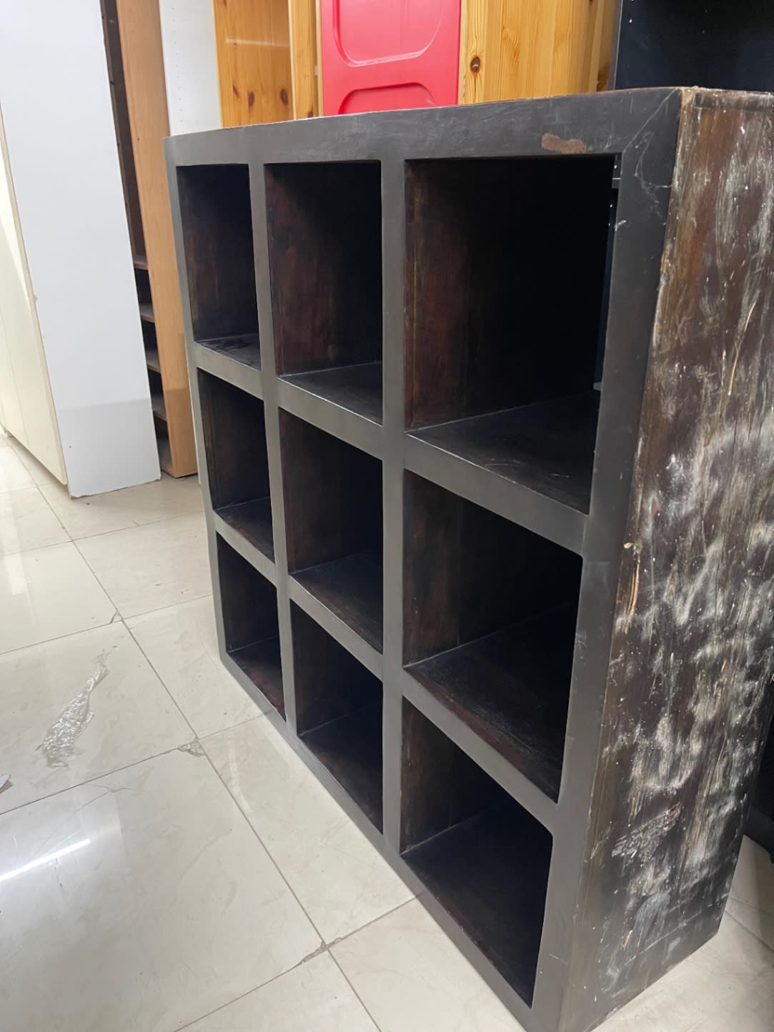 Side panel of used 9-cube storage bookshelf showing wear and scuff marks at Bufaisal Ajman