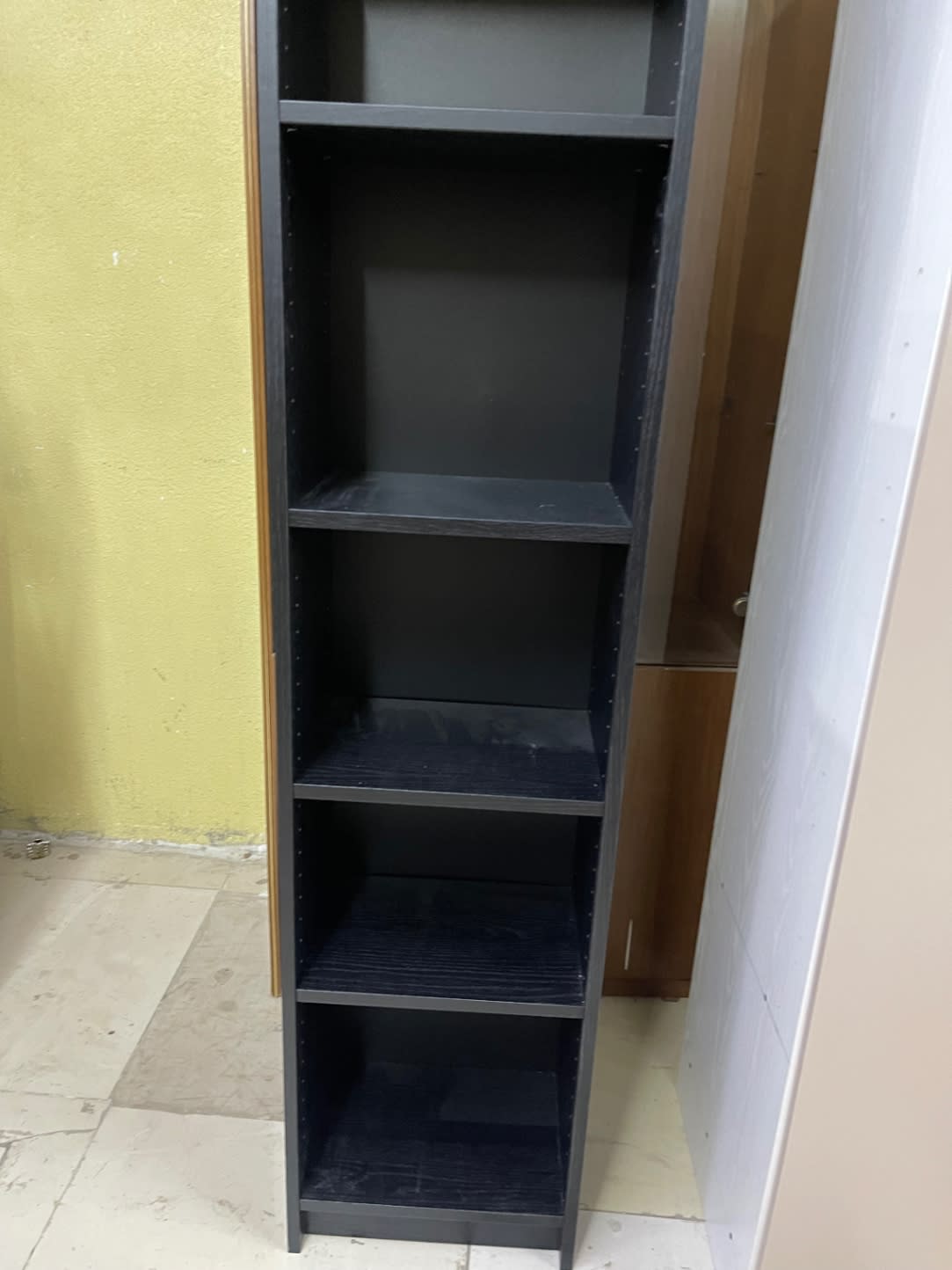 Barcode label photo for used black tall narrow bookcase at Bufaisal Ajman — label unreadable