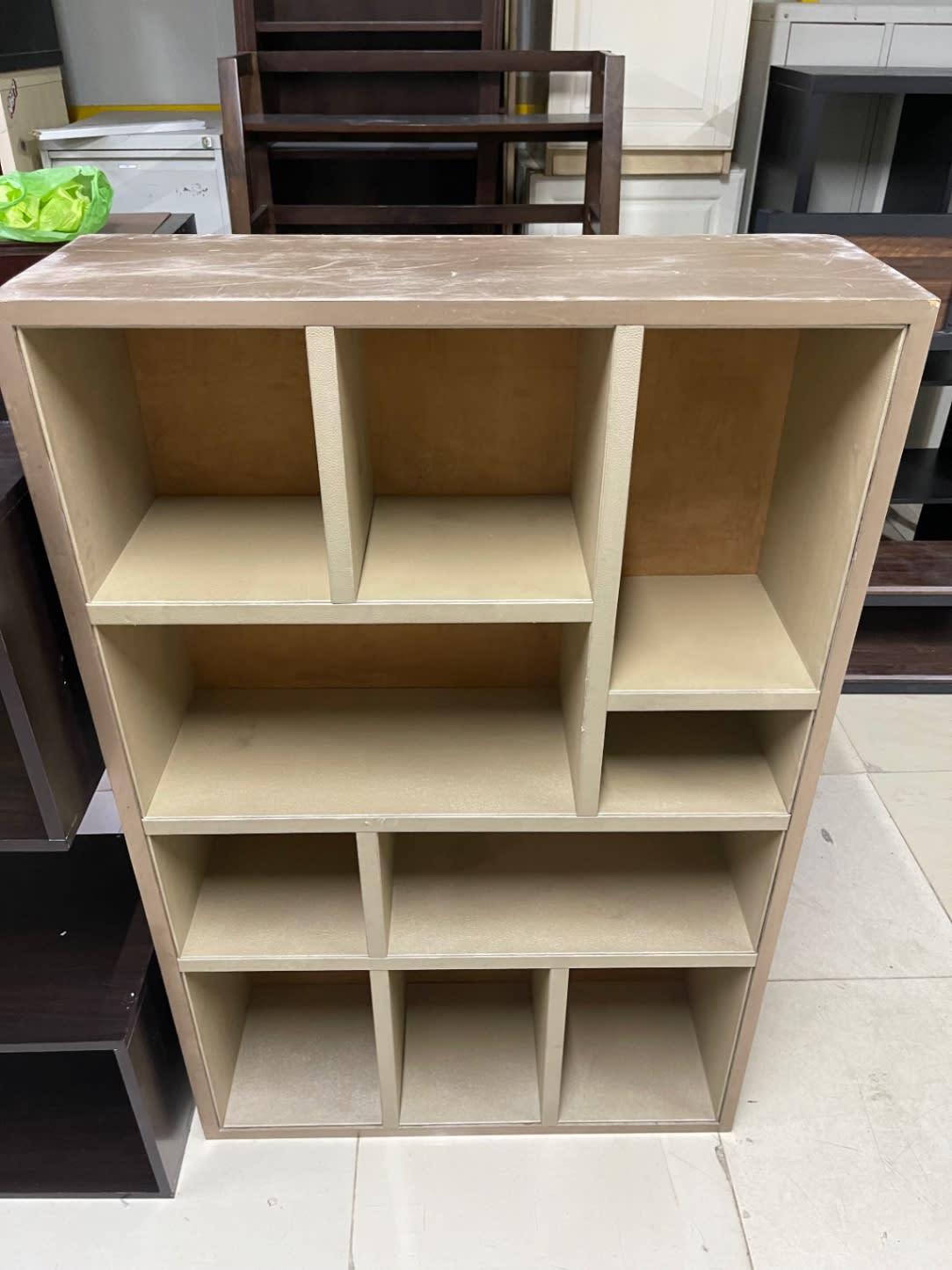 Top panel of used beige open bookshelf showing surface scratches, Shop C Ajman