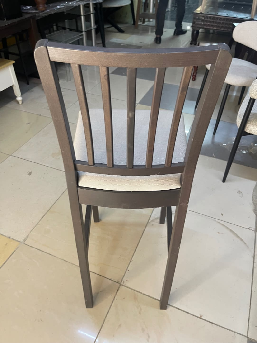 Rear view of used bar stool with vertical slat backrest showing minor surface marks on frame posts