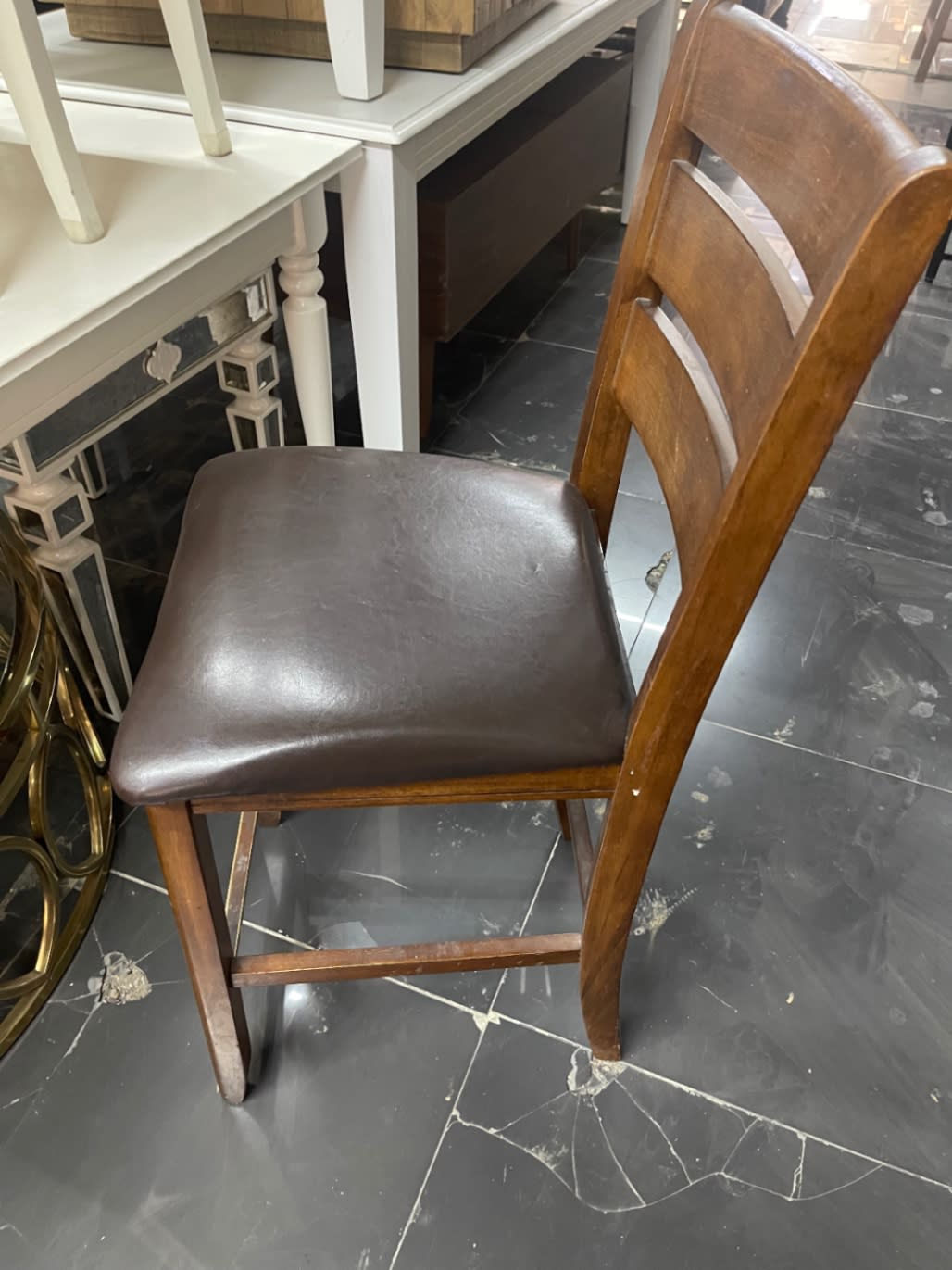 Rear angle of used ladder-back dining chair showing back slat detail and leg condition