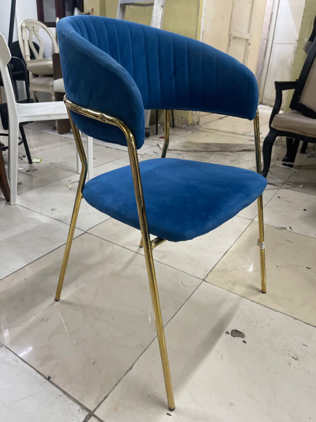 Rear angle of used blue velvet dining chair with gold-tone legs at Bufaisal Shop C Ajman