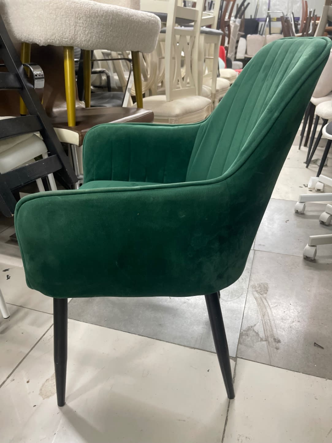 Side angle of used green velvet armchair showing armrest and leg detail at Bufaisal Ajman