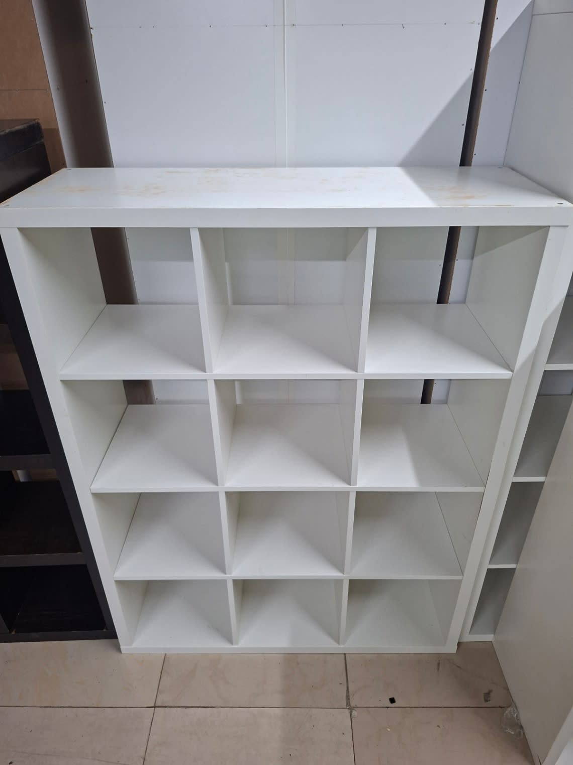 Top surface of used white 15-cube shelving unit showing minor staining
