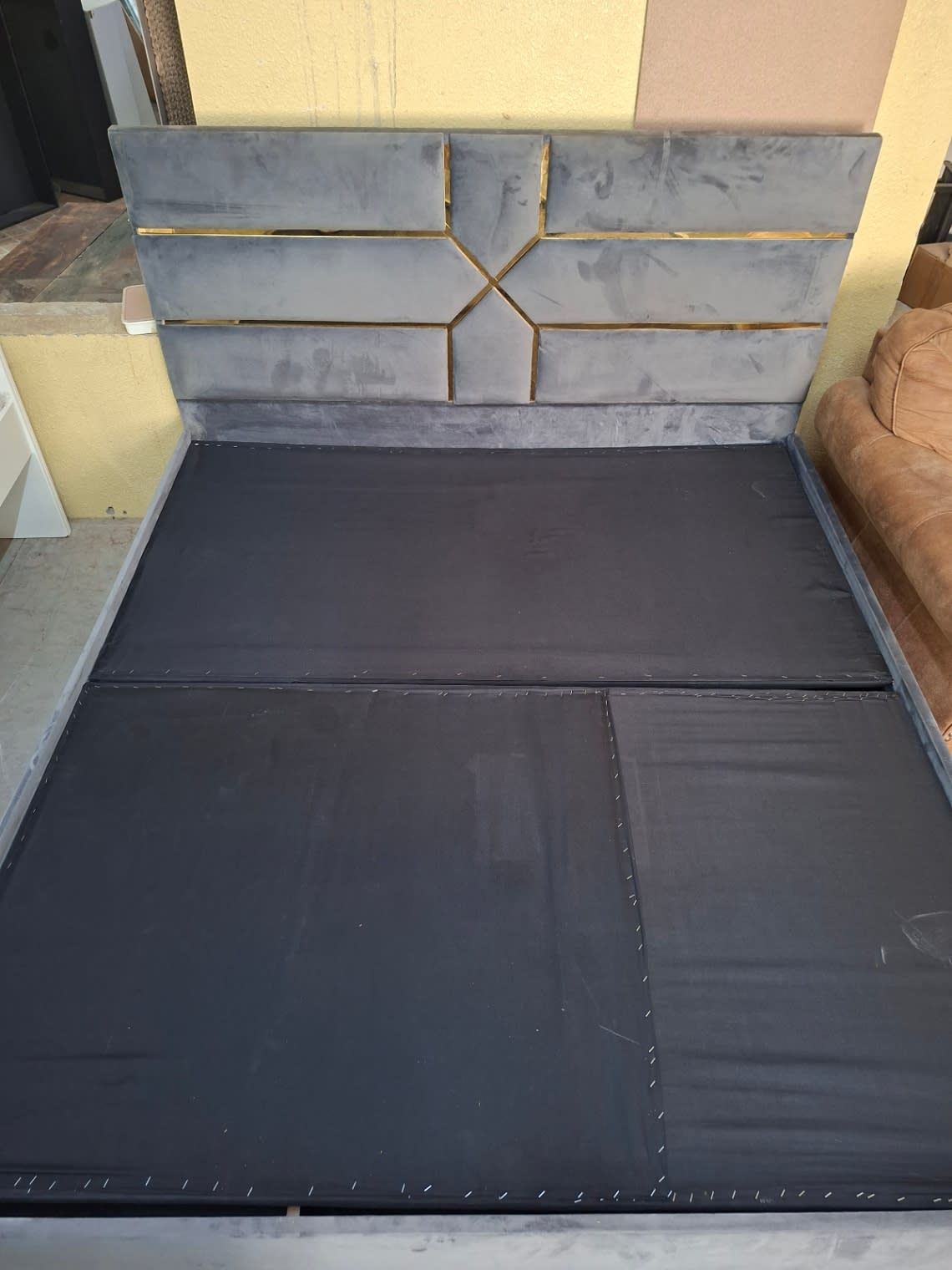 Overhead view of used grey velvet bed frame base panels showing good structural condition