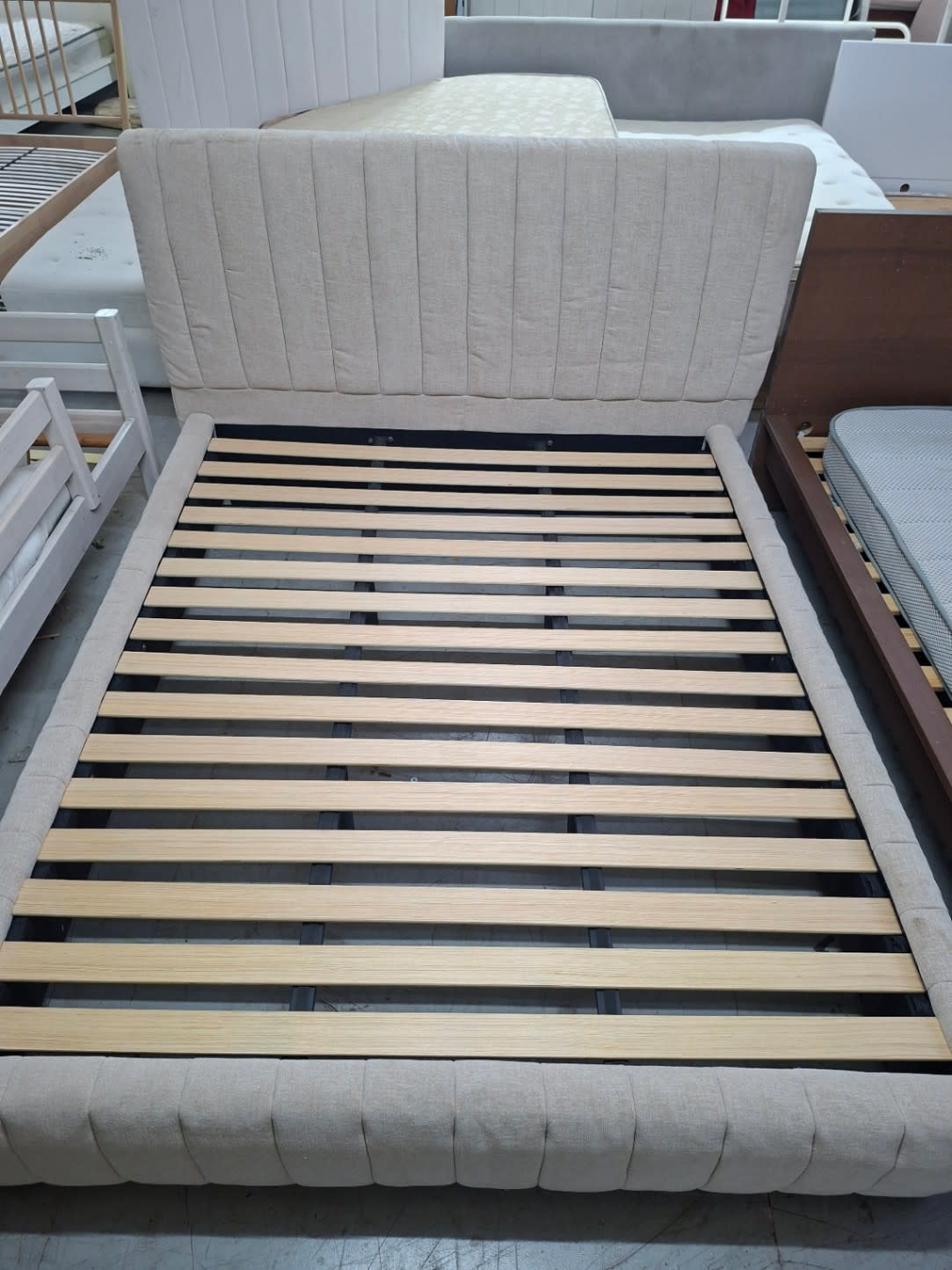 Top-down view of used beige king bed frame showing full wooden slat system at Bufaisal Ajman