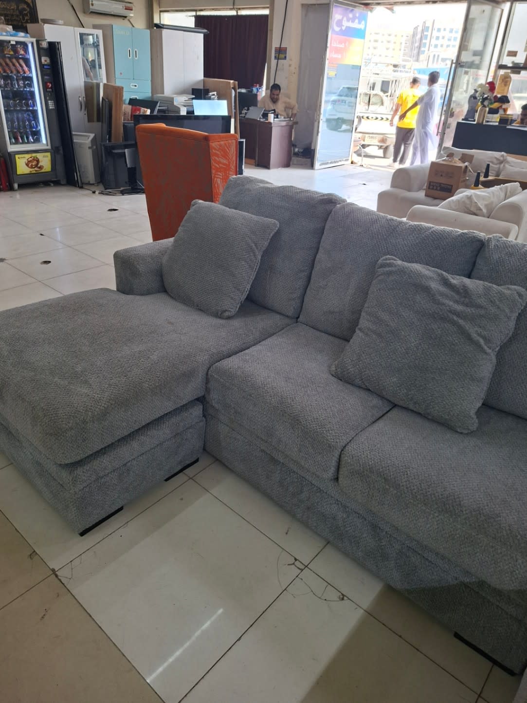 Bufaisal barcode label for used grey U-shape sectional sofa at Shop C Ajman