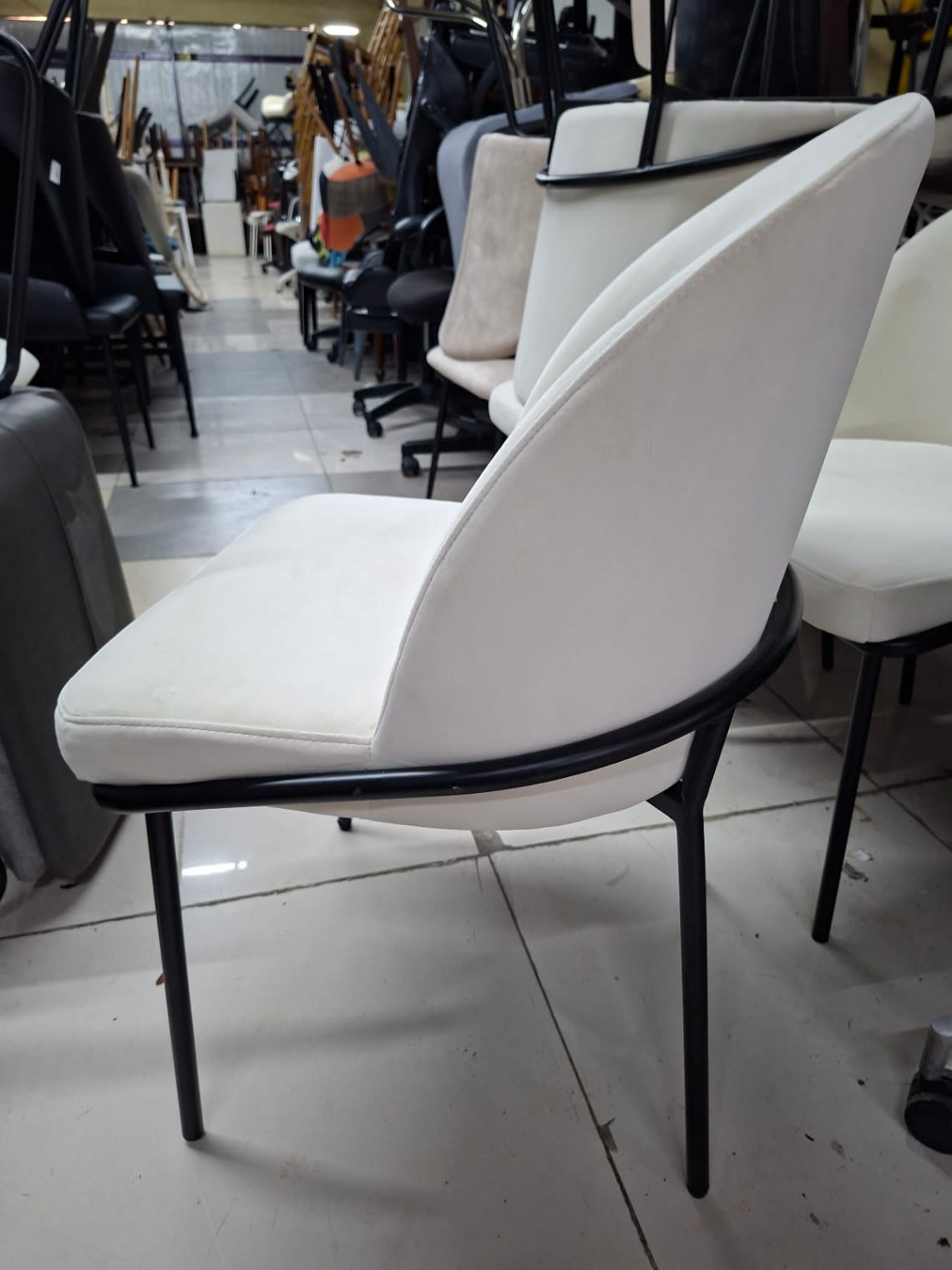 Another side angle of used off-white fabric dining chair with black metal legs at Bufaisal Shop C Ajman