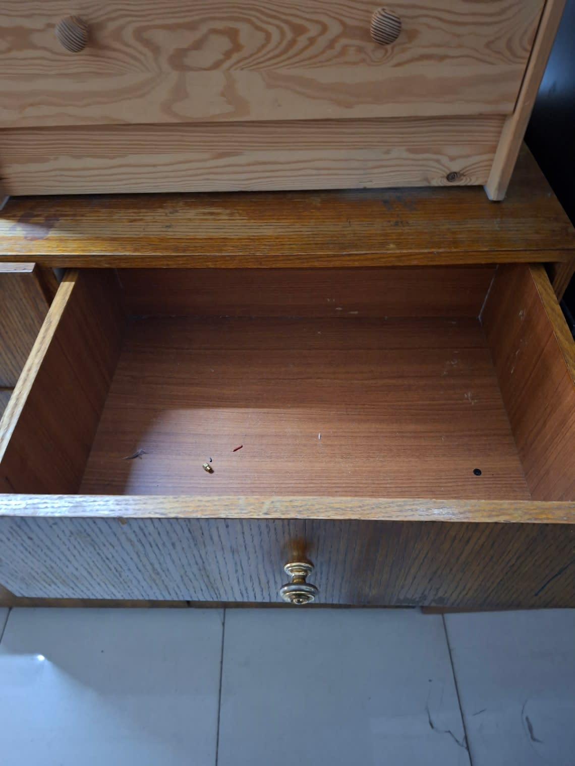 Open drawer of used shoe cabinet showing interior condition with minor marks