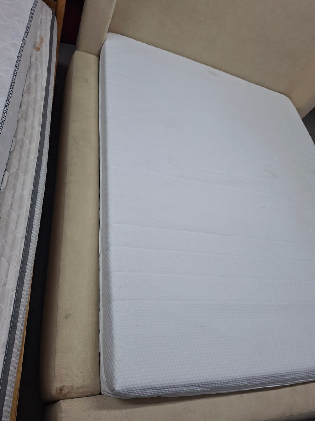 Top-down view of foam mattress with IKEA label resting in used queen beige bed frame at Bufaisal Shop C