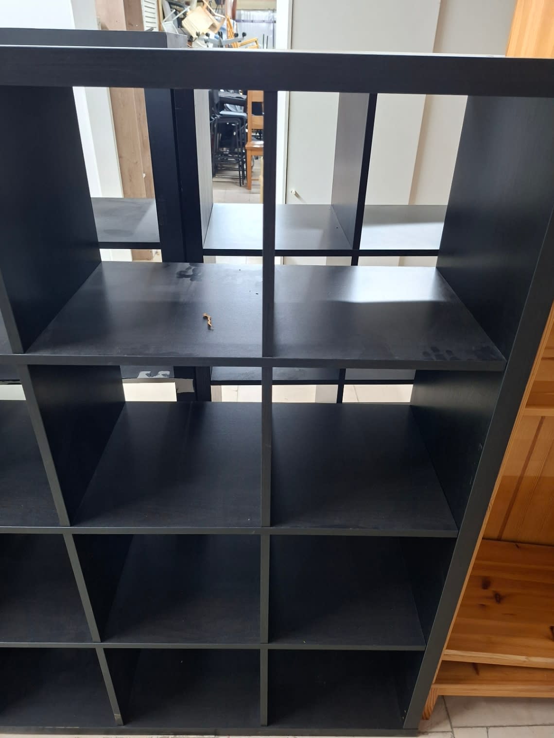 Fourth photo of used black-brown cube shelving unit showing interior shelf detail and minor wear