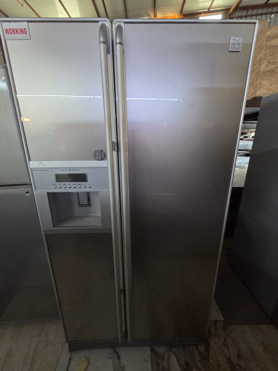Front view of used Daewoo side-by-side refrigerator with working sign at Bufaisal Shop D Ajman