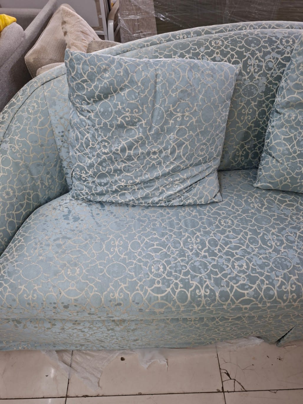 Close-up of seat cushion area of used teal 3-seater sofa showing wear and staining at Bufaisal Ajman