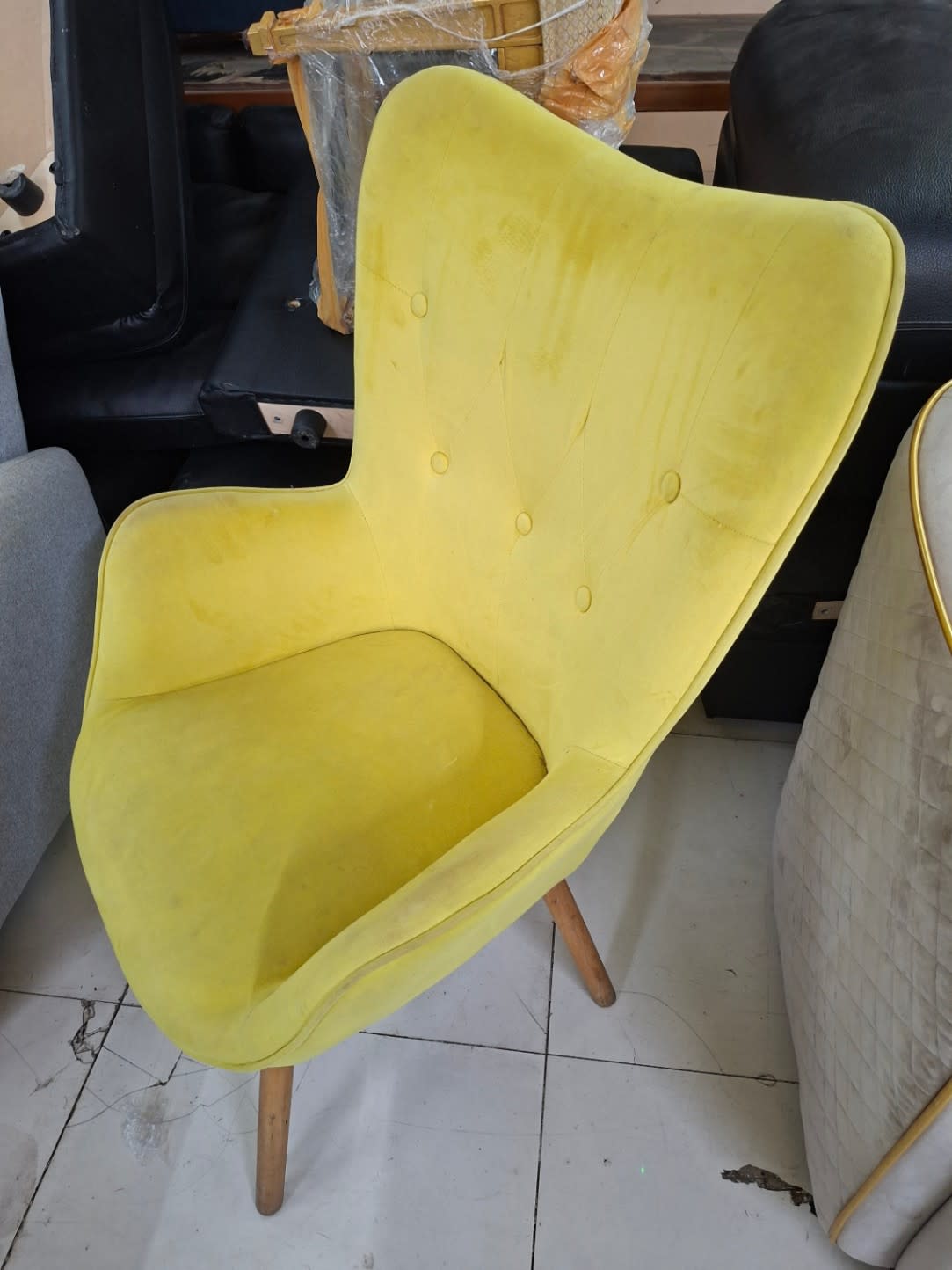 Additional angle of used yellow velvet accent armchair showing seat and armrest condition