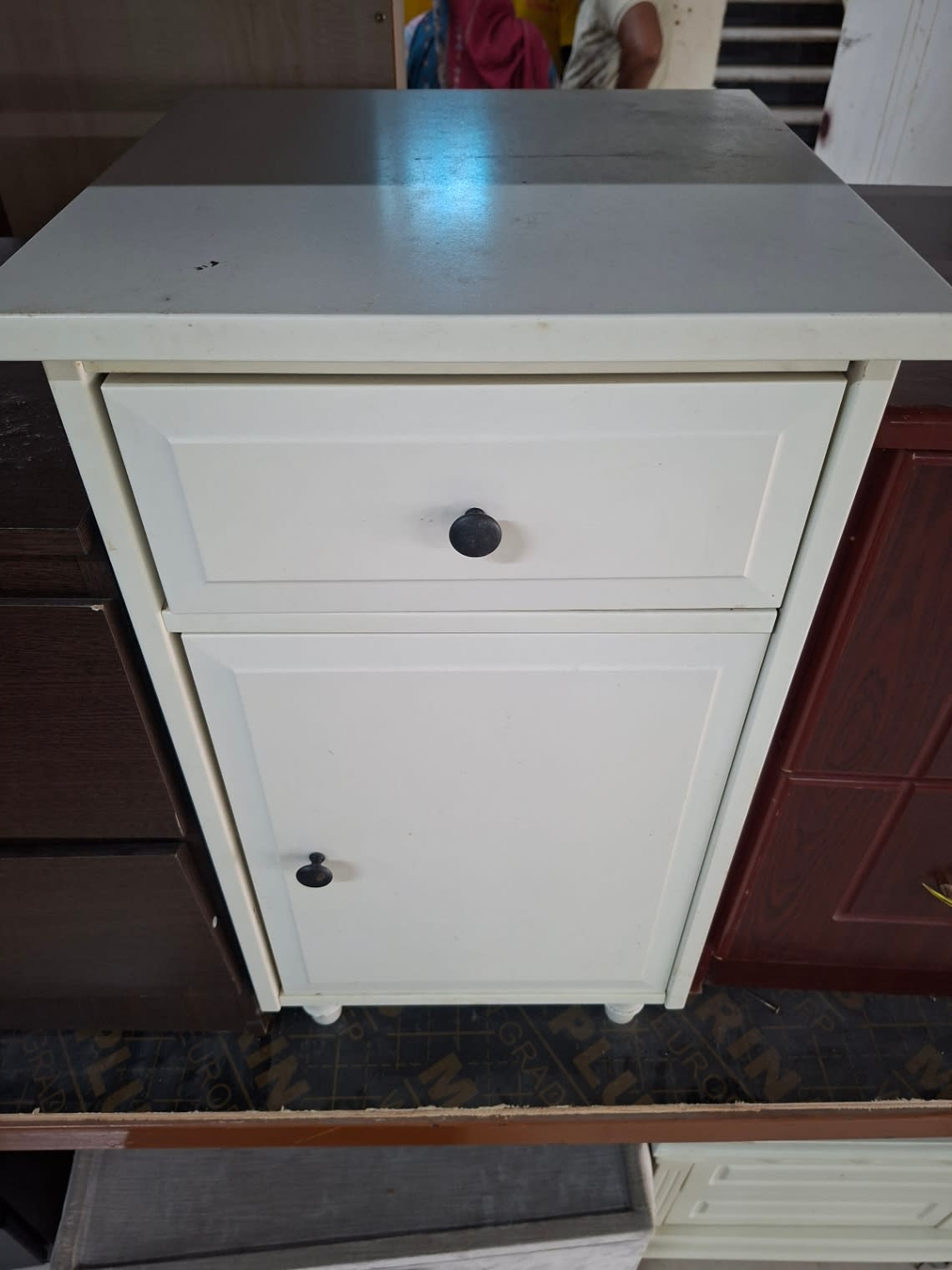 Angled front view of used white bedside table with drawer and door cabinet at Bufaisal Ajman