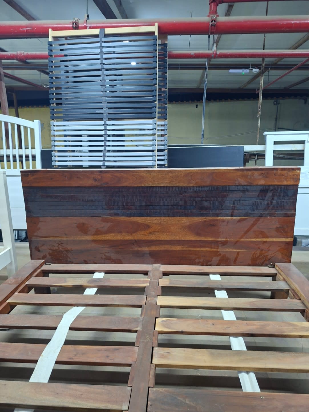 Headboard close-up of used queen wooden bed frame in walnut brown at Bufaisal Ajman