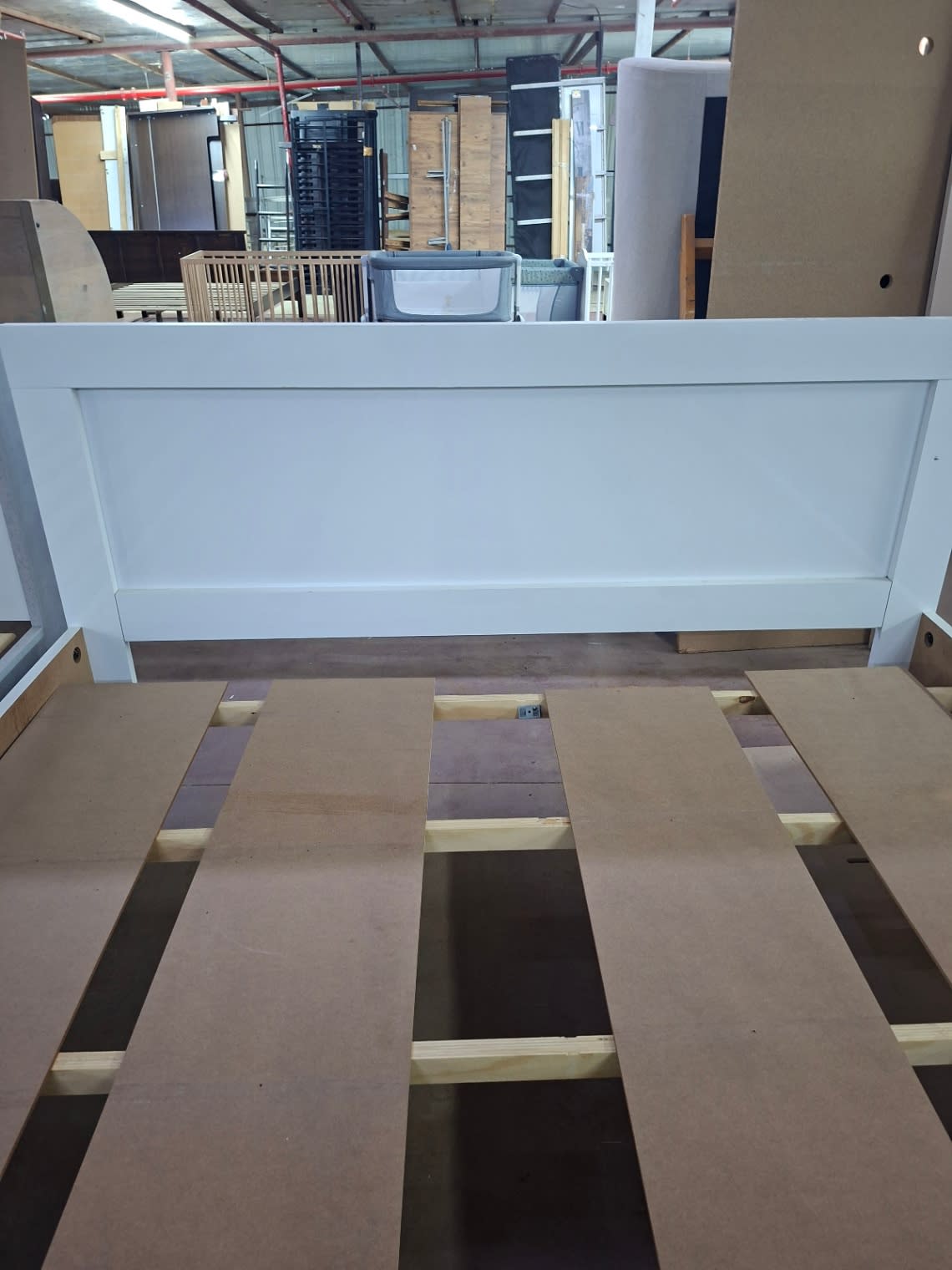 Headboard close-up of used white queen bed frame with wooden slat support at Bufaisal Ajman