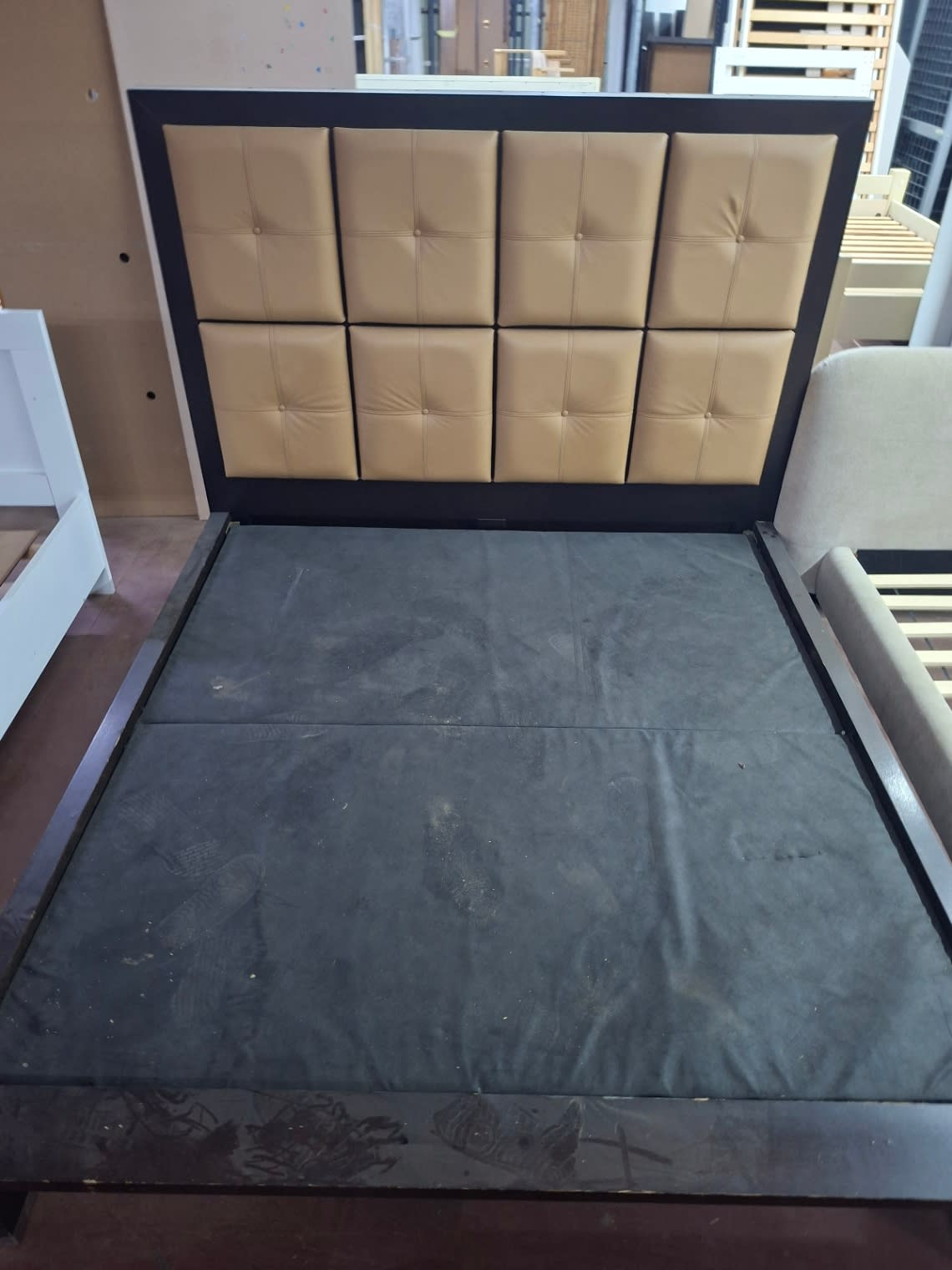 Top-down view of used king bed frame platform base showing surface dust and storage wear