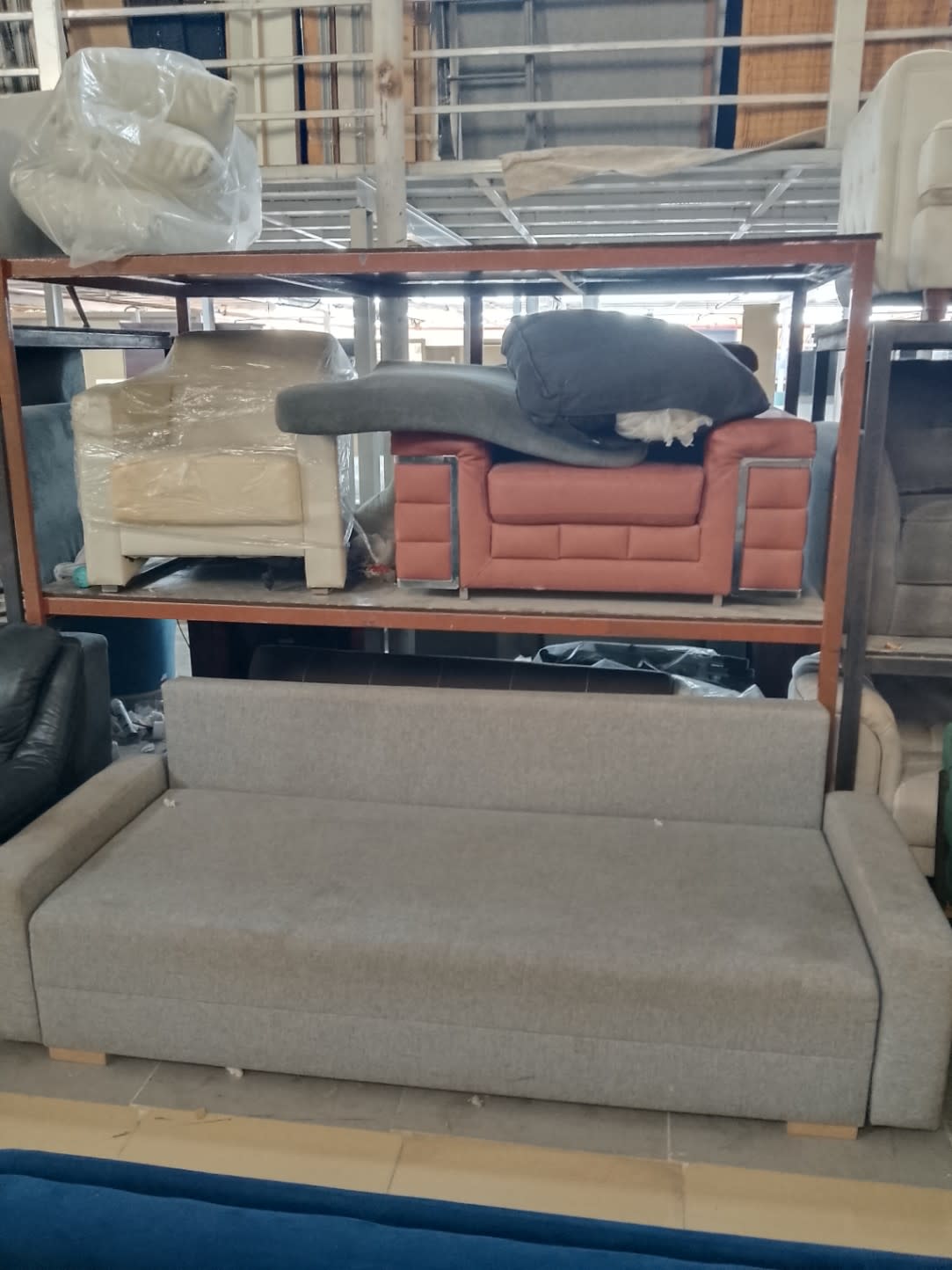 Used 3-seater grey sofa bed at Bufaisal Ajman — barcode label not readable