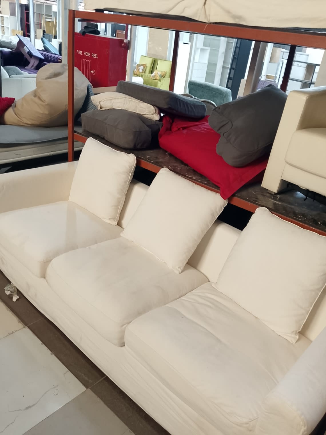 Close-up view of used off-white 3-seater sofa cushions and fabric condition at Bufaisal Ajman