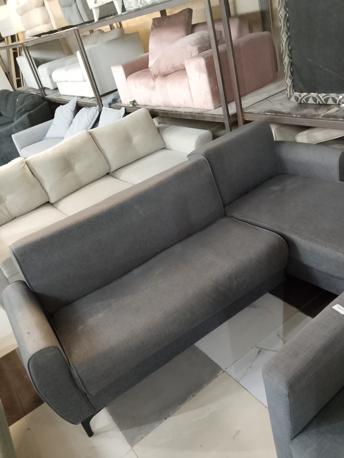 Top view of used dark grey L-shape sectional sofa main seat section showing surface wear at Bufaisal Ajman