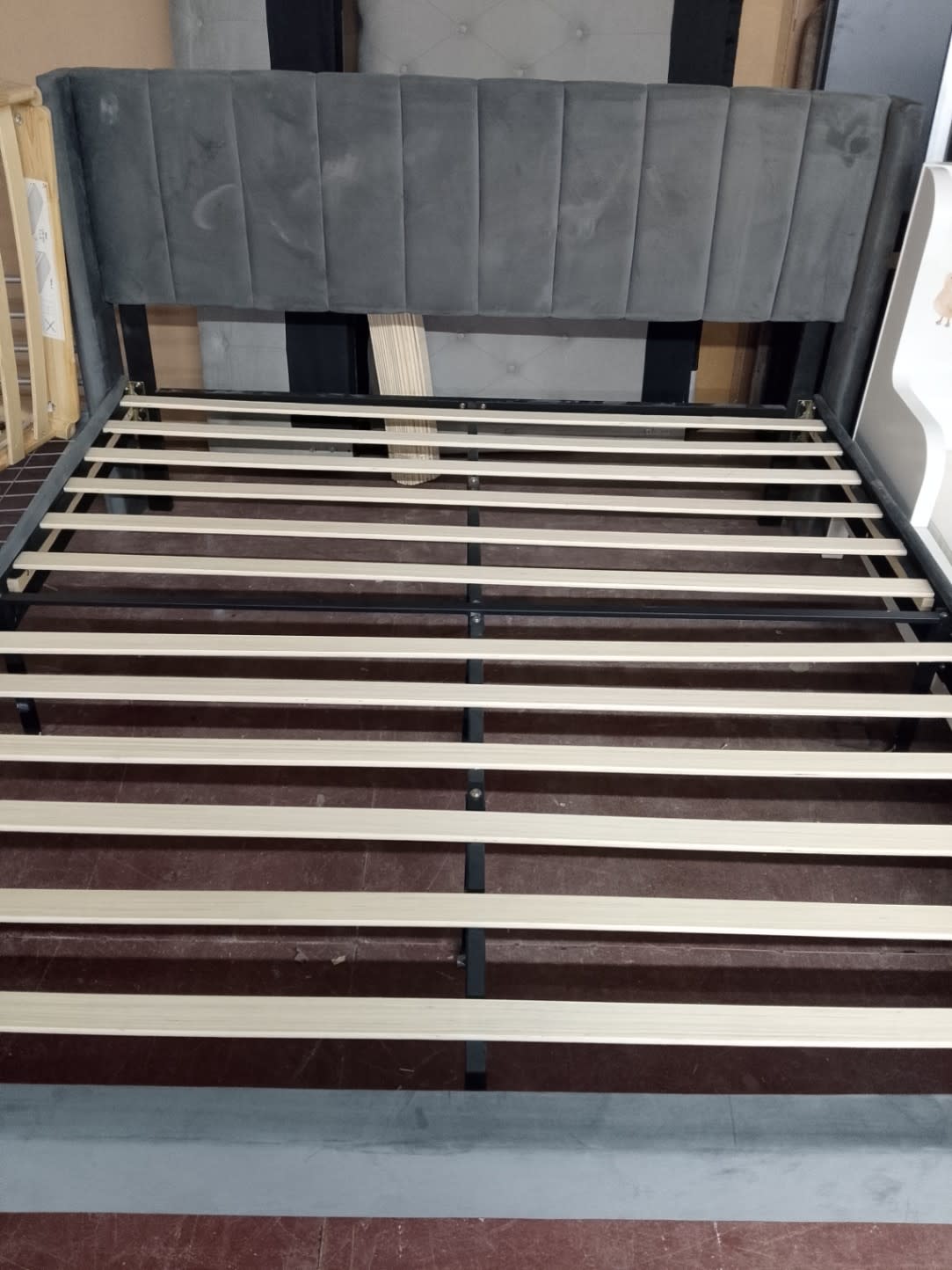 Barcode label photo for used grey upholstered bed frame at Bufaisal Ajman — label unreadable