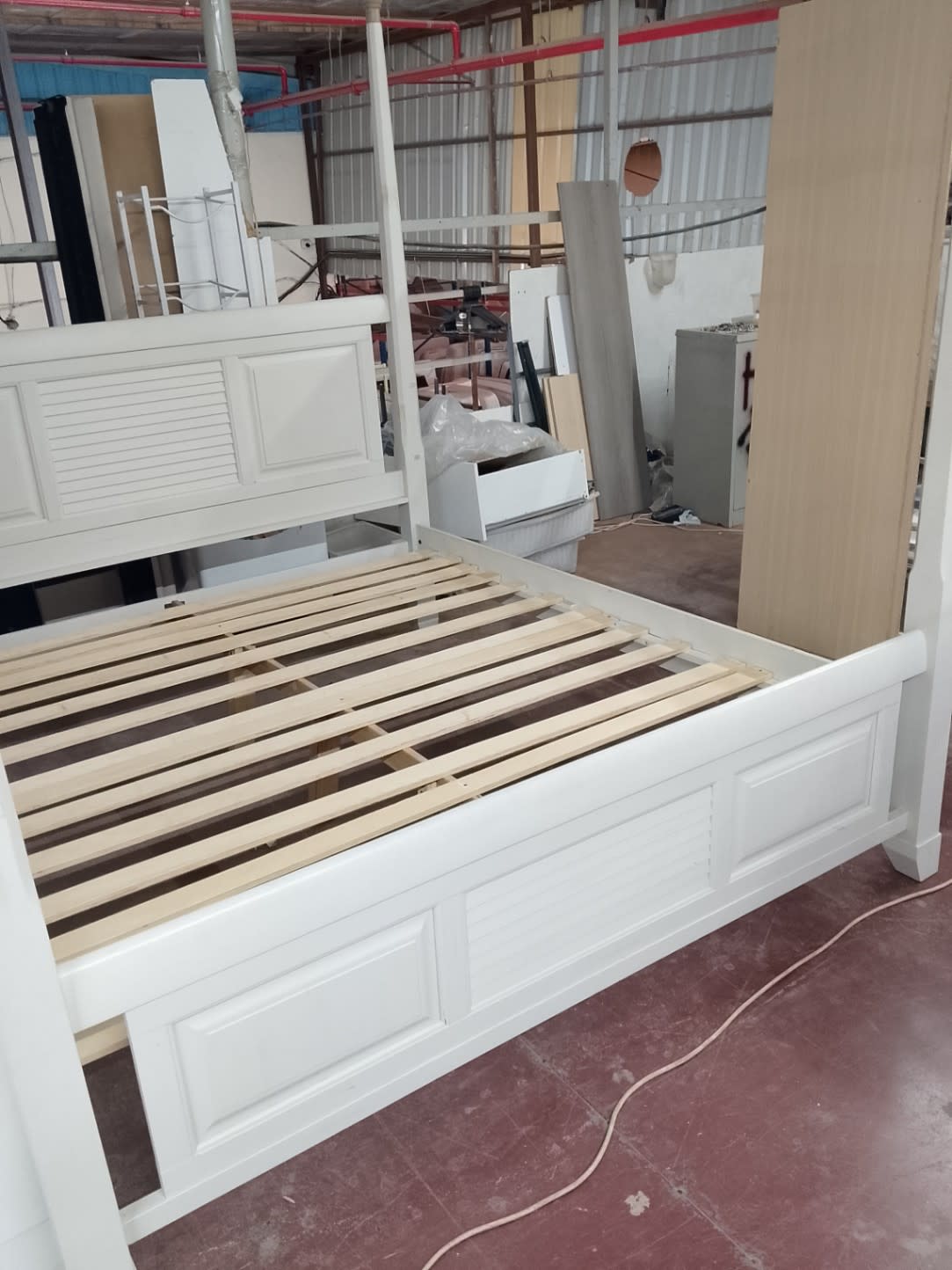 Side angle of used white four-poster king bed frame showing footboard panel detail at Bufaisal Shop D Ajman
