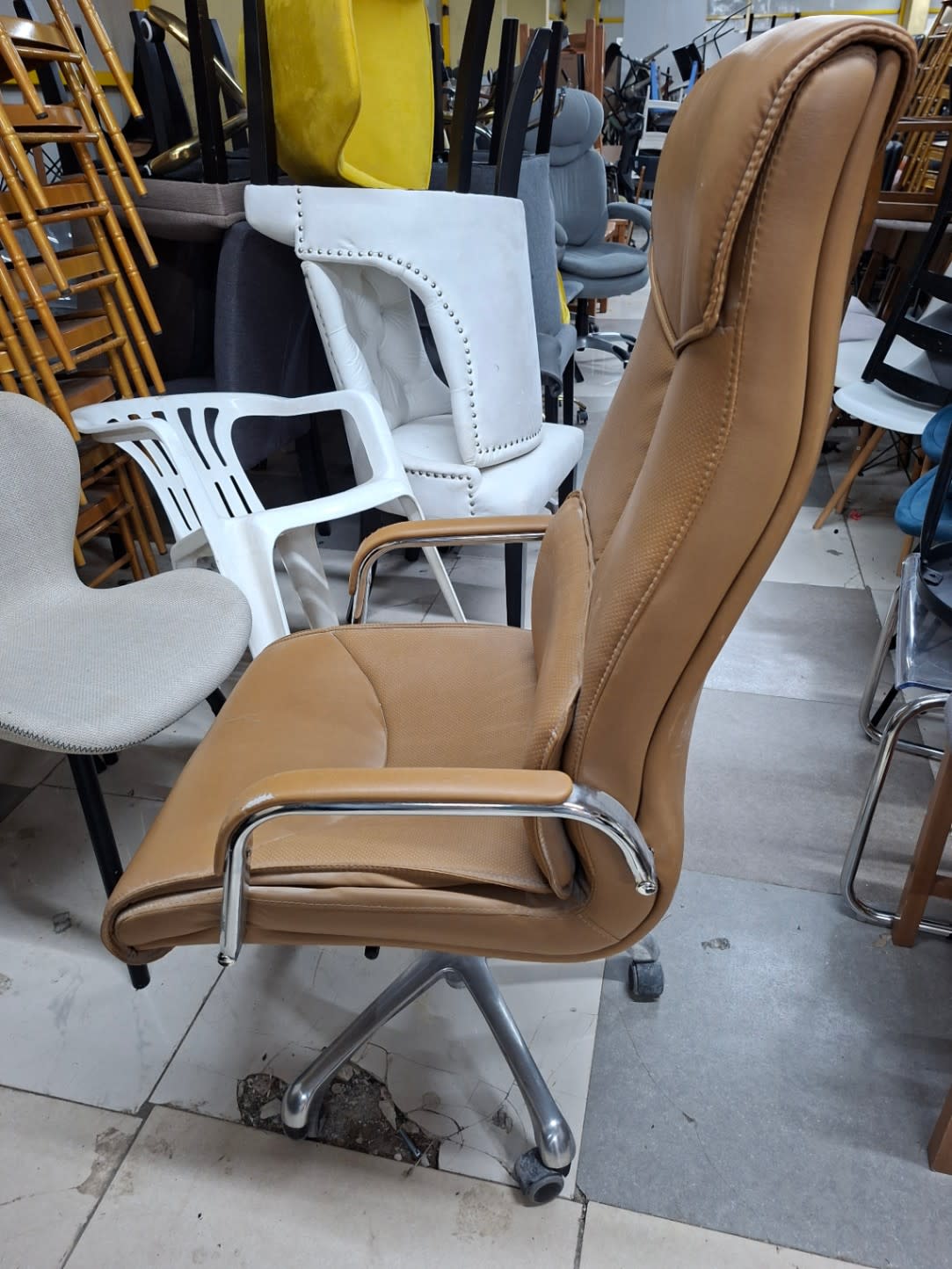 Second side angle of used high-back executive office chair tan showing seat and armrest condition