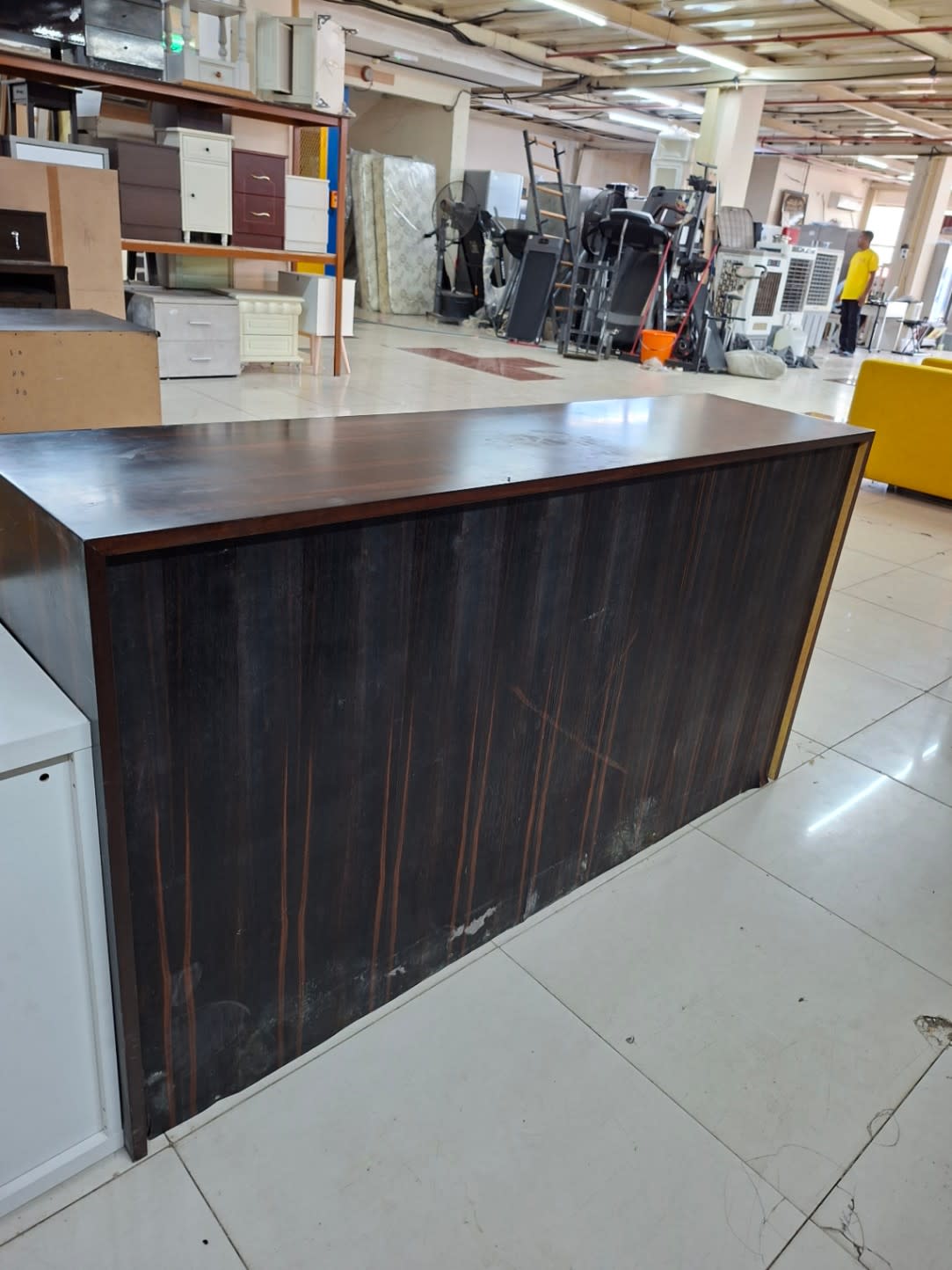 Back panel of used dark brown sideboard cabinet showing scratches and scuff marks from prior placement
