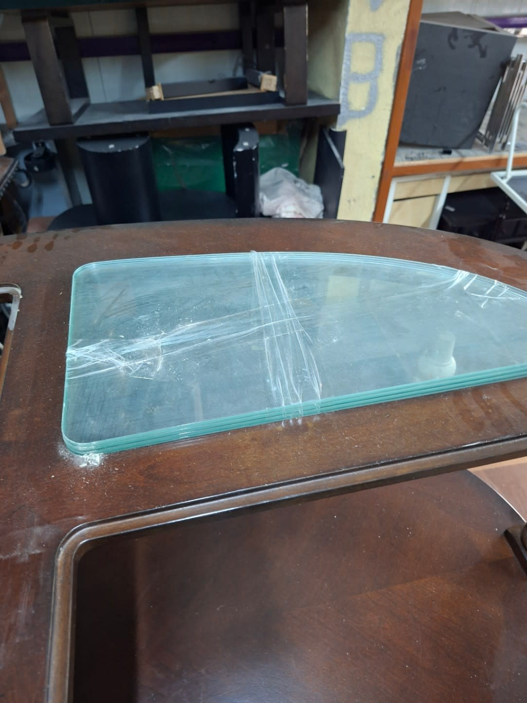 Close-up of heavily scratched glass insert panels on used oval coffee table at Bufaisal Ajman