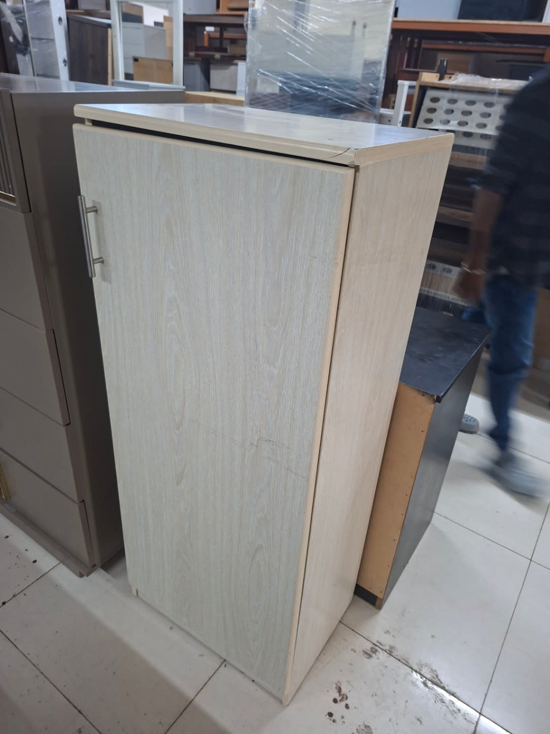 Angle view of used single-door shoe cabinet showing surface scratches on door panel