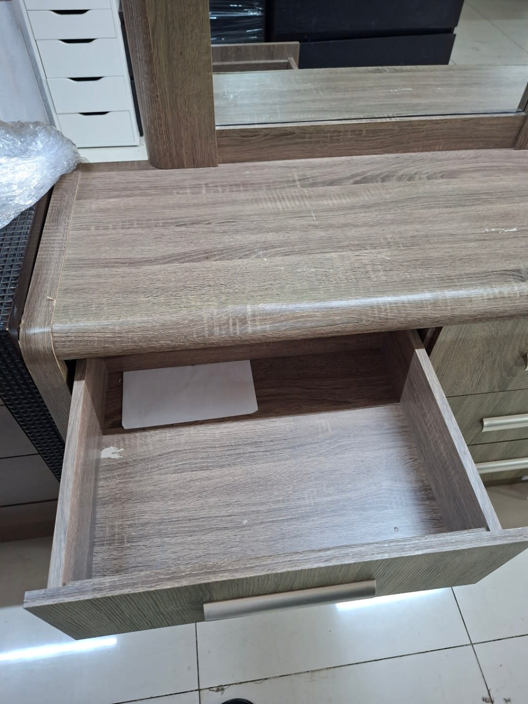 Open drawer of used 6-drawer dresser showing interior condition and light scratches on top panel