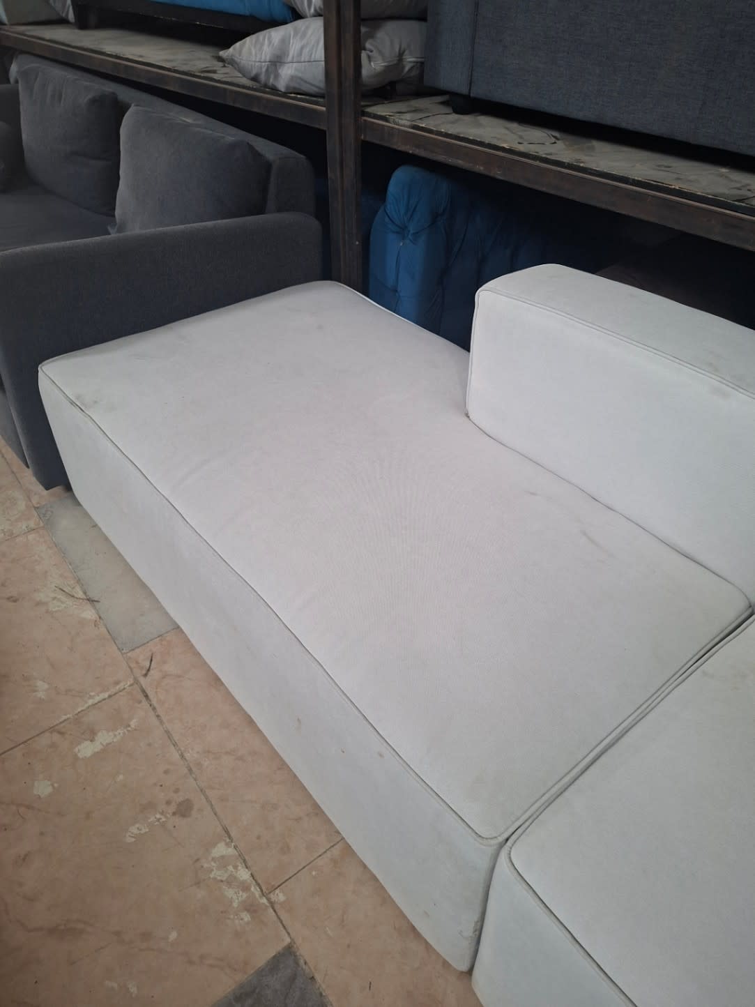 Seat surface detail of used L-shape sectional sofa showing light surface marks on fabric