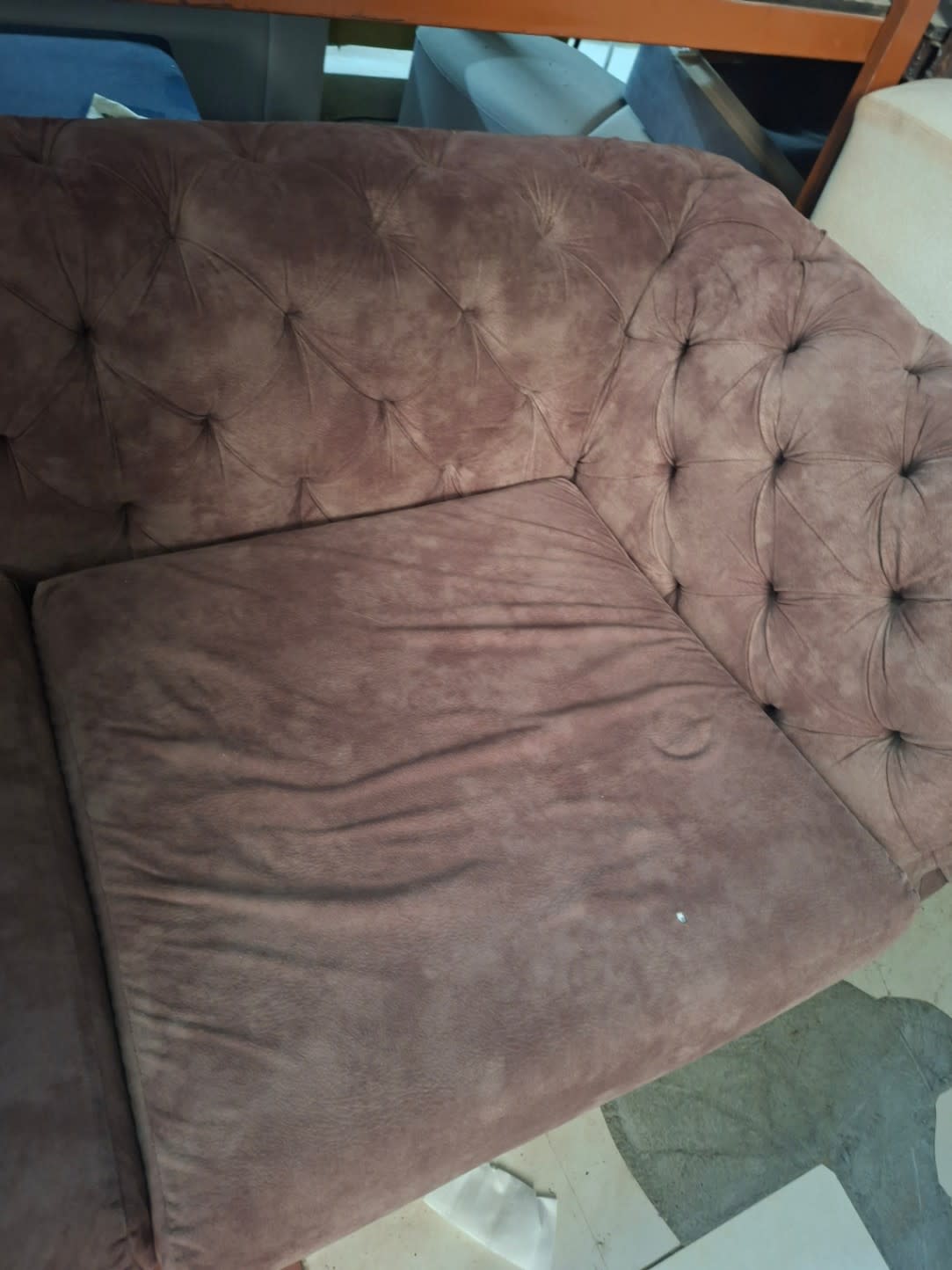 Top-down view of used Chesterfield 3-seater sofa seat showing fabric condition and tufting