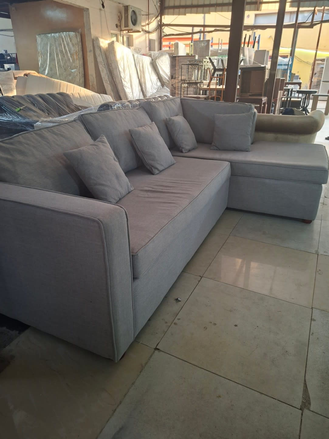 Side angle of used grey L-shape sectional sofa with chaise at Bufaisal Shop D Ajman