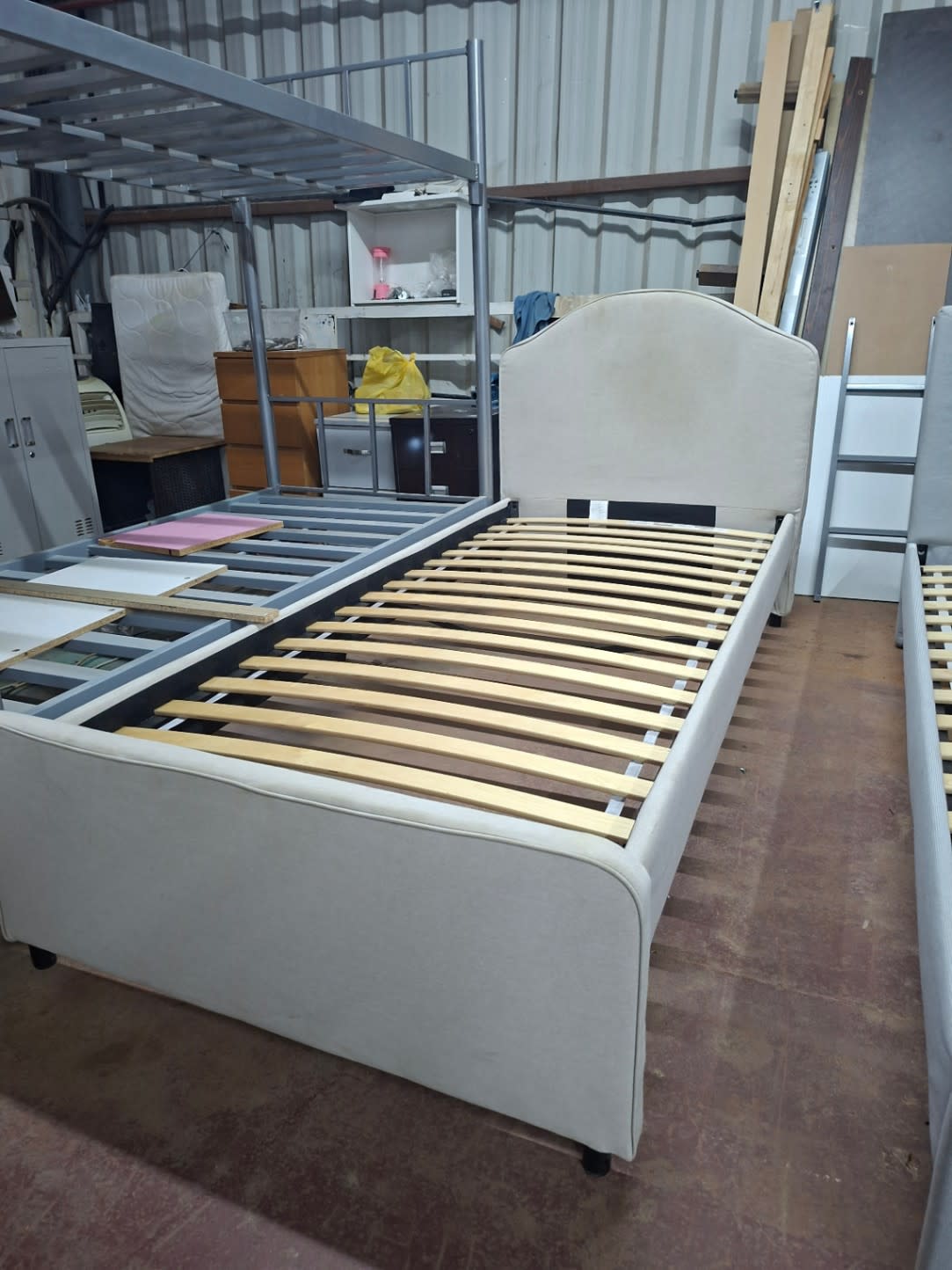 Full side view of used IKEA single upholstered bed frame showing headboard, footboard, and slats