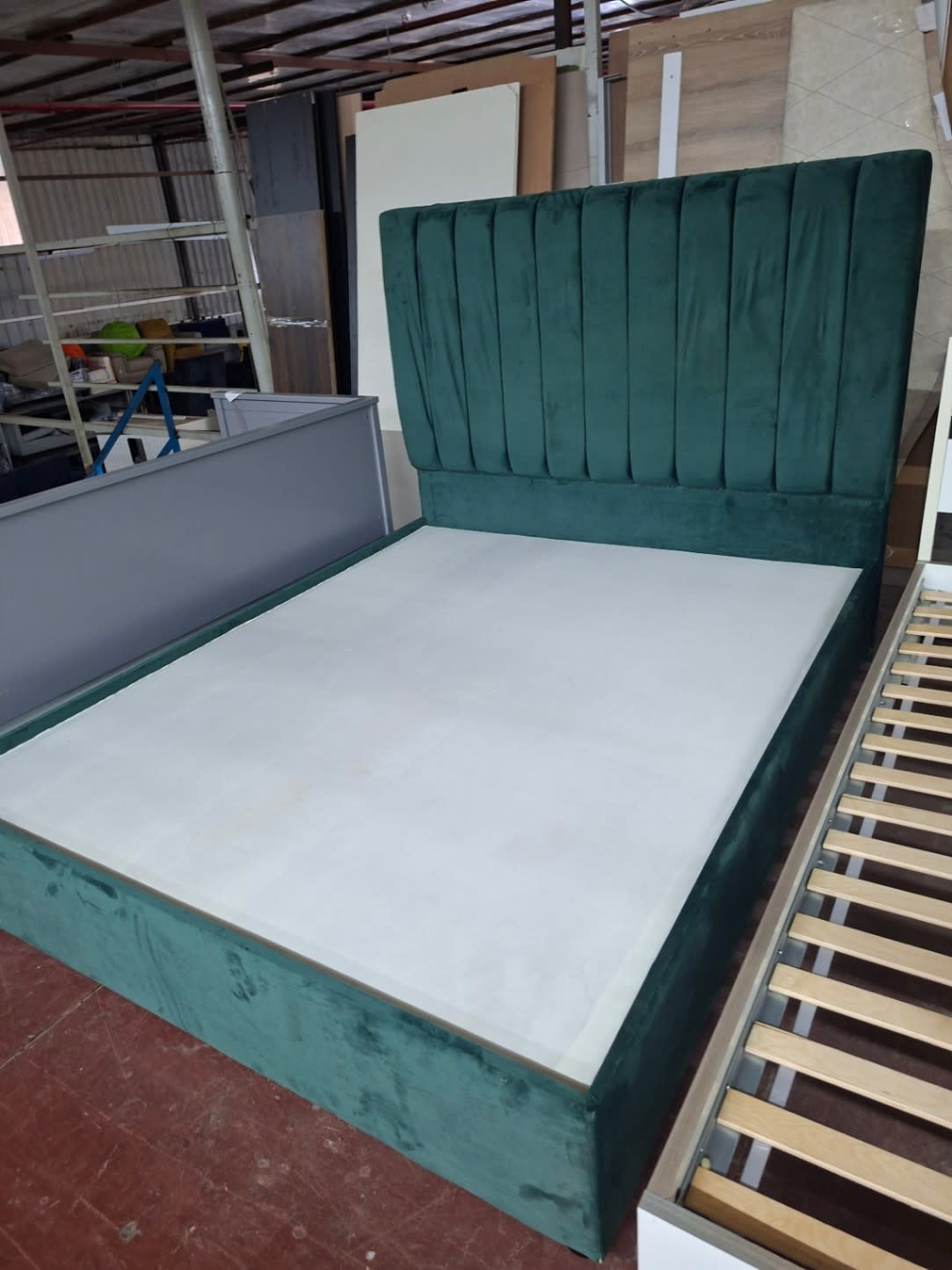 Side angle of used green velvet bed frame showing base fabric and headboard at Bufaisal Ajman