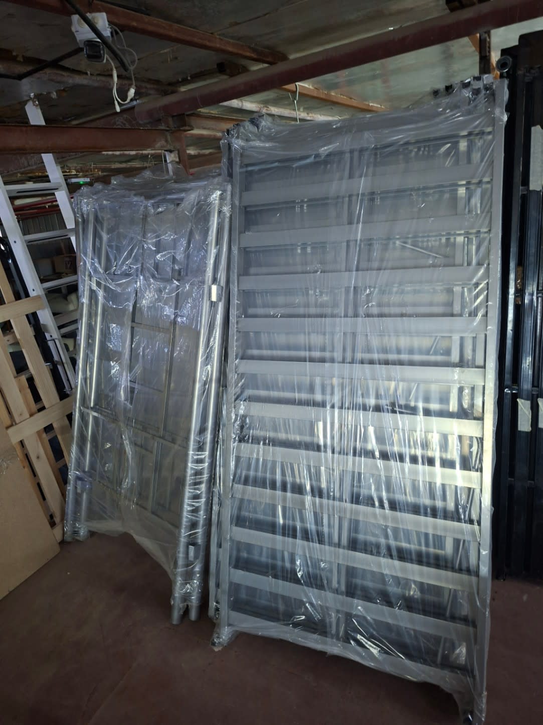 Full view of new grey metal slatted bed frame unassembled and wrapped at Bufaisal Shop D Ajman