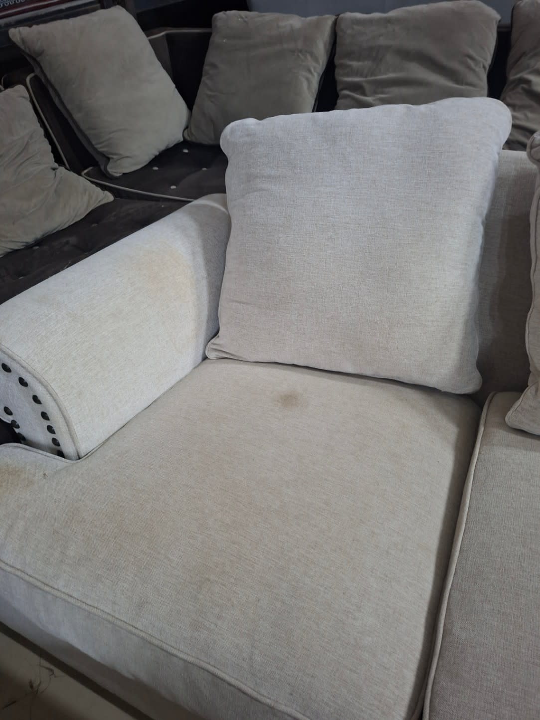 Close-up of used beige sofa seat cushion showing light stain detail at Bufaisal Shop D Ajman