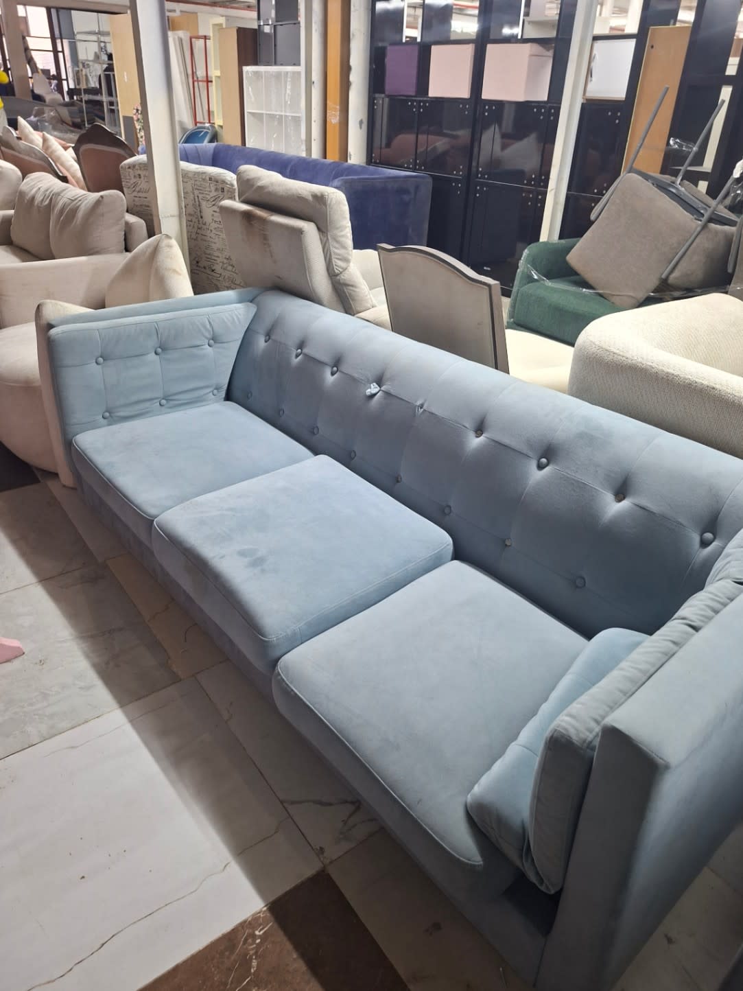 Top-down view of used light blue 3-seater tufted sofa showing seat cushion condition at Bufaisal Ajman