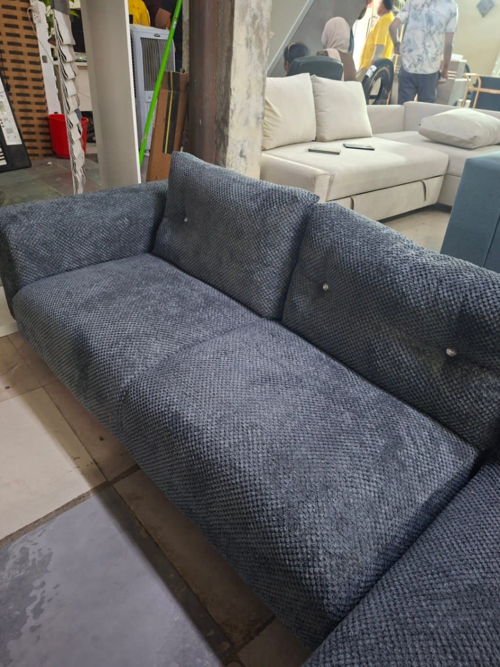 Side angle view of new dark grey L-shape sectional sofa with metal legs at Bufaisal Ajman